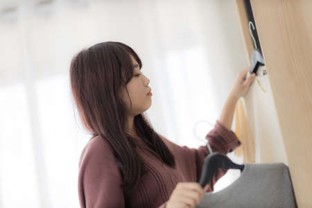 asian woman, housewife is putting the t-shirt in the closet.の写真素材