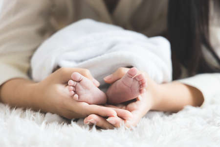 Close up newborn baby 's foot in mother 's hand. Mother 's day concept.の写真素材