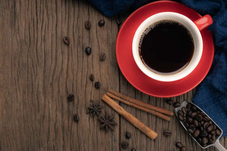 Top view of red cup of black coffee on with cinnamon wooden table and copy space.の写真素材