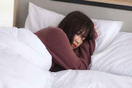 Asian young woman is sick and sleep in the bedroom. A girl hangover from a party last night and she...