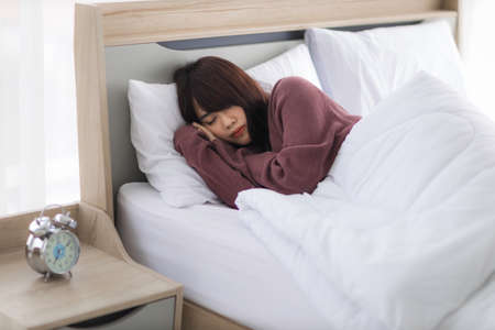 Asian young woman is sick and sleep in the bedroom. A girl hangover from a party last night and she is having a nightmare.の写真素材