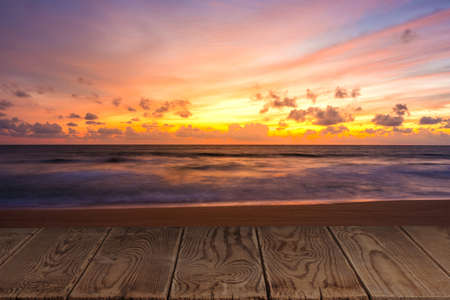 Empty wooden table with view of beautiful beach in the twilight period.