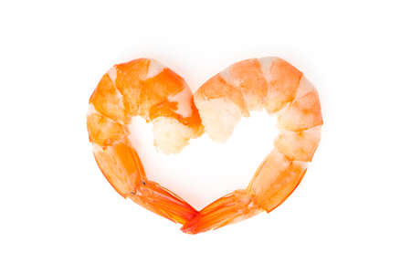 Boiled shrimps are heart shaped on white background.の写真素材