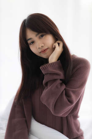 Portrait of beautiful young Asian woman is smiling in bed.の写真素材