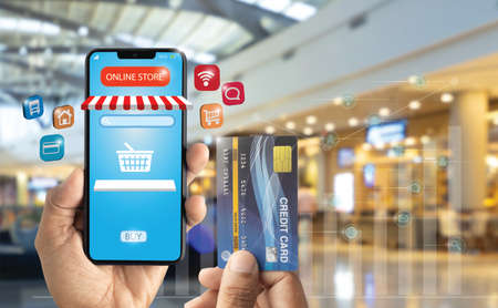 Hand-holding smartphone for online store with market background. New normal and social distancing....