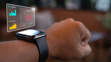 Close up smart watch on the wrist of a man who is exercising tells his heart rate. Step count and calories burned. Technology and healthcare concept.の写真素材
