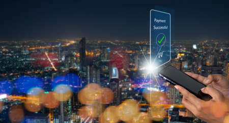 Woman using smart phone for online payment, banking in night city background. E-commerce, market, and shopping online concept.の写真素材