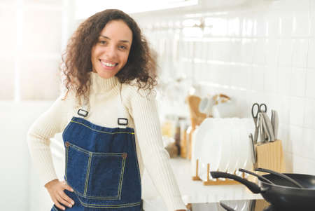 Portrait of beautiful woman is smiling in the bright white kitchen. wife or housewife is preparing to cook healthy food for the family. recive order for food delivery.の写真素材