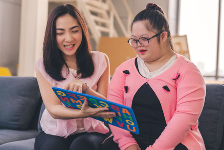 young girl with autism is practicing fun playing with toys at home with his mother. Autistic young students are learning with teachers happily.の写真素材