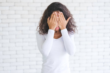 Portrait African American millennial women feeling stressed and worried after overwork. Younger females have symptoms of afflicted onset syndrome. Office workers are feeling bored.の写真素材