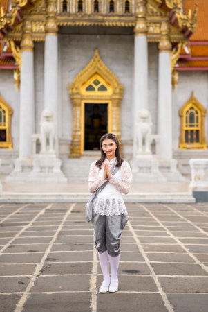 Portrait of beautiful young woman wearing Thai Rattanakosin national costume in a temple built according to Thai art in Thailandの素材