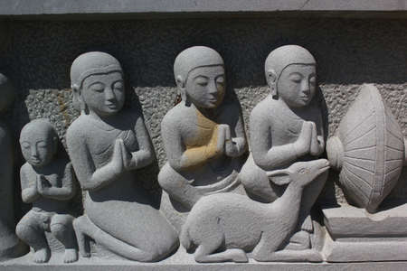 Wall sculpture devoted followers of Buddhism の写真素材