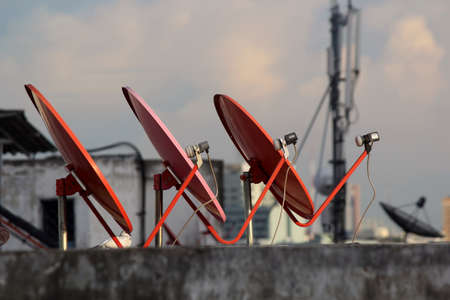 Three a Satellite dish on the roof in the evening の写真素材