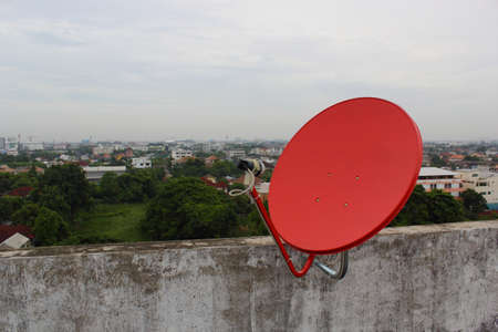 Red satellite dish on the roofの写真素材