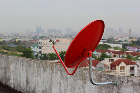 Red satellite dish on the roofの写真素材