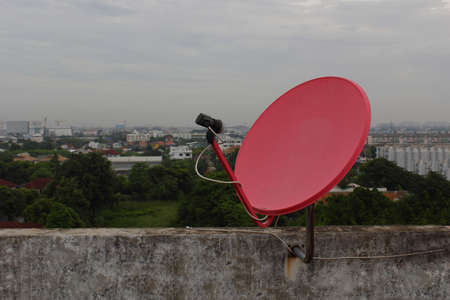 Red satellite dish on the roofの写真素材