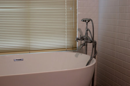 Bathroom interior with white bathtub and brown tile wall.の写真素材