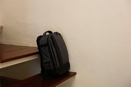 Grey Backpack on Wooden Stairsの写真素材