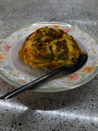 Thai style omelet with rice and chopsticks on the table