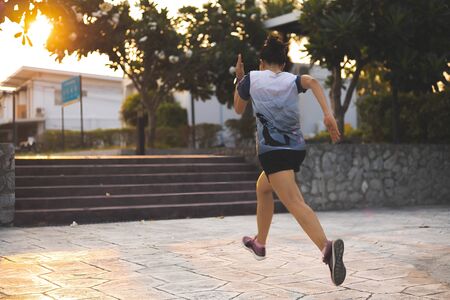 Fitness sports women fast running in the village center park.
