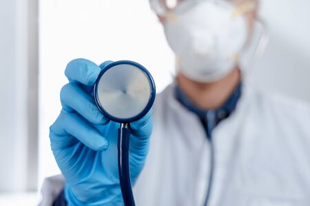 A doctor holds his stethoscope to insinuate that it's time for a check up in clinic banner panoramic crop for copy space.の写真素材