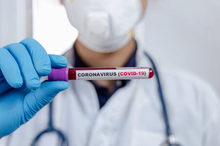 Laboratory testing patientâs blood samples for presence of coronavirus (COVID-19) The doctor holds a test tube containing a blood sample that has no the result positive or negative for coronavirus.の写真素材