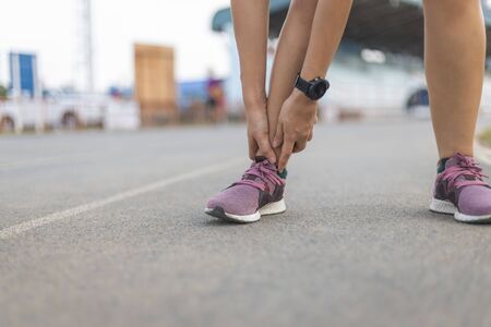 the runner woman injured after running. She is touching on Ankle that is painful area.