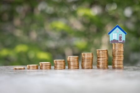 Money Financial, Business Growth,loan and real estate investment concept. house model on gold coins to stack of coinsの写真素材