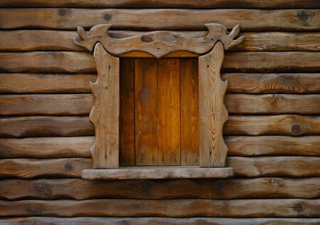 Fragment of wooden wall with window in the centerの写真素材