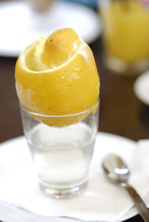 Ice cream inside lemon fruit with glass of hot water  Spanish desert の写真素材