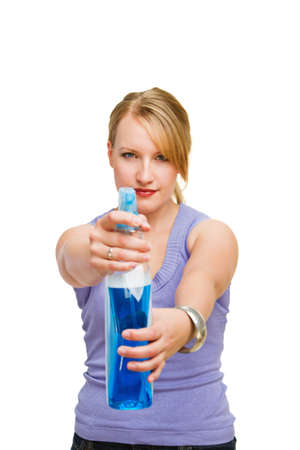Young beautiful housewife aiming cleaner bottle at youの写真素材