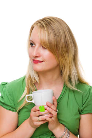 Thoughtful young woman looking to her side, holding tea cupの写真素材