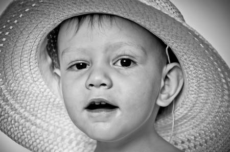 The surprised little boy in a straw hatの写真素材