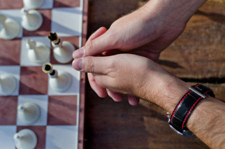 Hands of a chess player with board