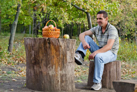 Sitting Man reminiscing while looking into the fruit basket in the parkの写真素材