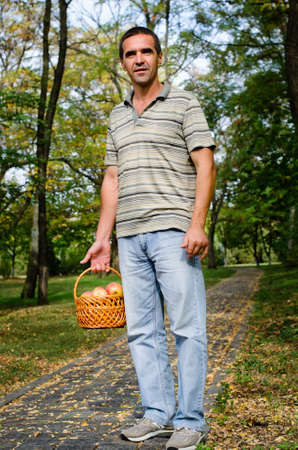 Man in the park holding a fruit basketの写真素材