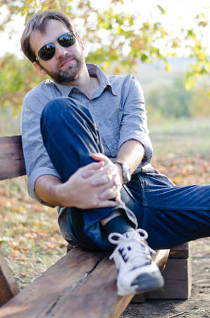 Man sitting with his hands on knee in a close up shotの写真素材