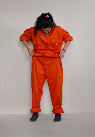 Woman checking the fit of her orange overalls