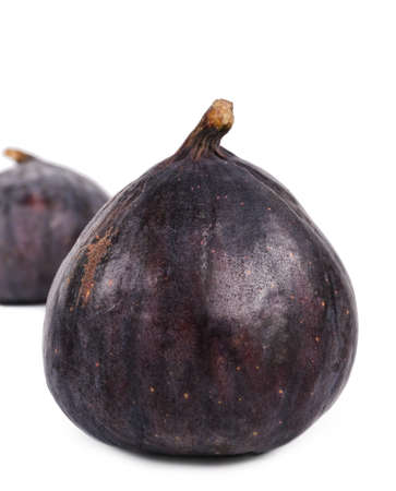 Two delicious whole ripe purple figs for a succulent healthy dessert or snack on a white backgroundの写真素材