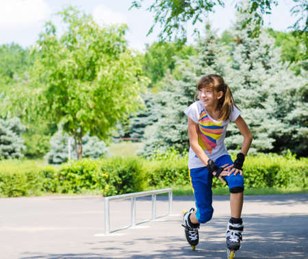 Teenage girl limbering up before going roller skating stretching her muscles and bending while laughing and smiling in anticipationの写真素材