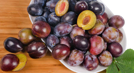Full frame image of a large group of fresh plums on wooden tableの写真素材