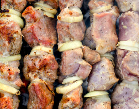 Close up overhead view of delicious lean beef kebabs cooking over a fire on a barbecueの写真素材