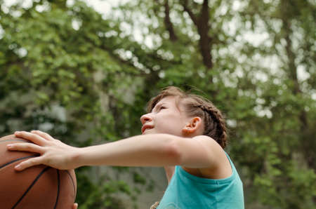 Determined young girl about to shoot a basketball