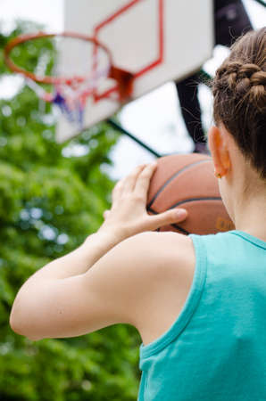 Determined young girl about to shoot a basketballの写真素材