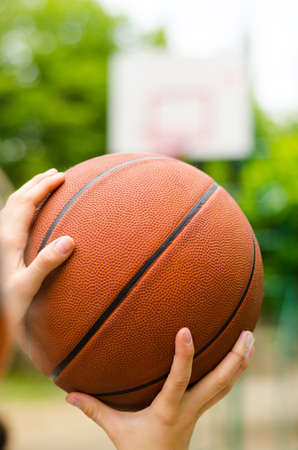 Basketball in hand against hoopの写真素材