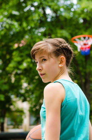 Determined young girl about to shoot a basketballの写真素材