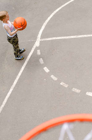 Young boy playing basketball in an outdoor court top viewの写真素材