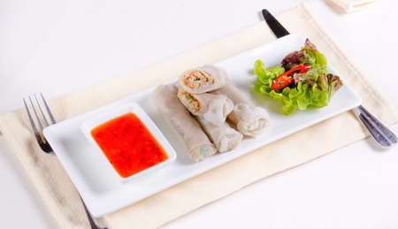 Gourmet Meaty Chinese Spring Rolls Main Dish with Sweet Chili Dipping Sauce and Fresh Lettuce on...