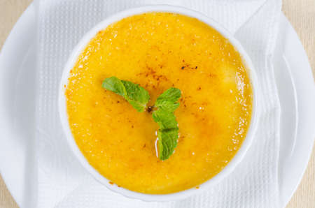 View from above of a bowl of tasty autumn butternut or pumpkin soup garnished with cayenne pepper and fresh mintの写真素材