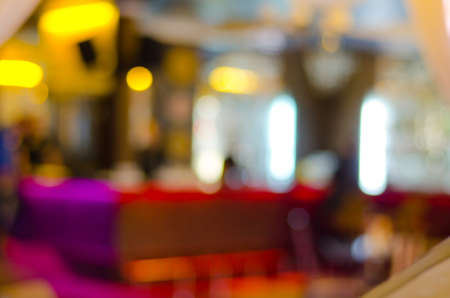 Warm yellow lights and white neon in a blurred interior of a fancy location for food and drinks as a restaurant, cafeteria or barの写真素材